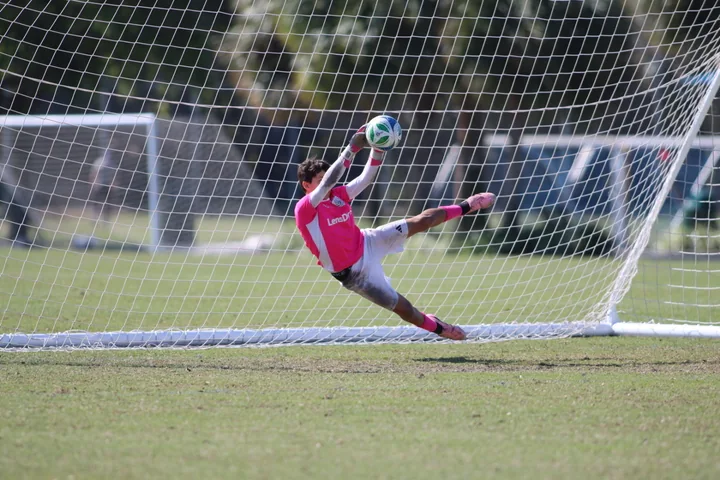 Gavin airborne with both hands on the ball